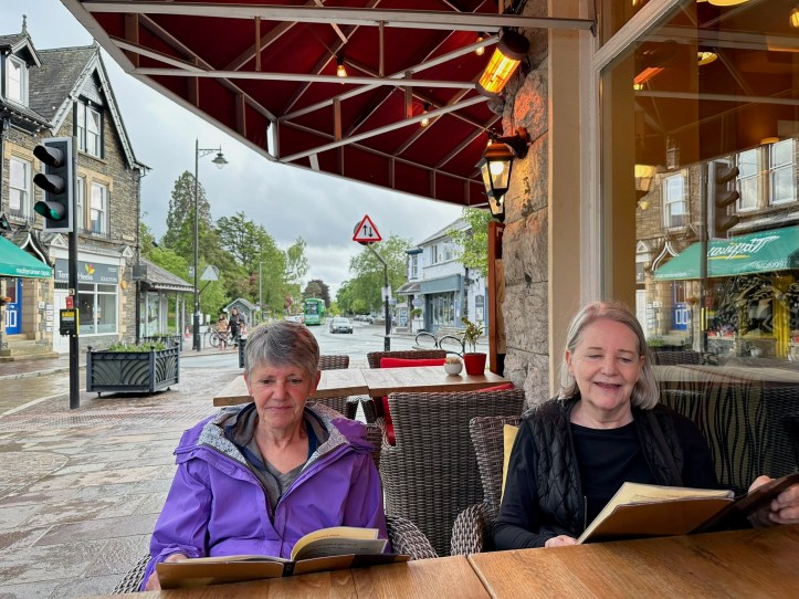 Sisters Tracy and Karen sitting at an outdoor cafe table.